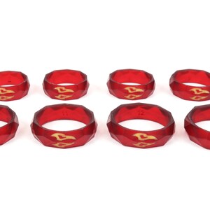 May include: Set of eight red silicone rings with a gold design. The rings are numbered 10 through 13.
