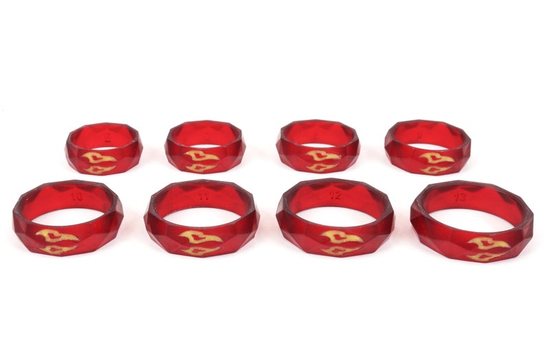 May include: Set of eight red silicone rings with a gold design. The rings are numbered 10 through 13.