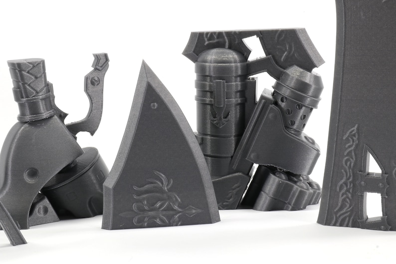 May include: A set of 3D printed gray plastic pieces for a model kit. The pieces are detailed and have intricate designs.
