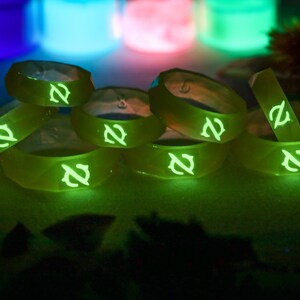 May include: A stack of eight glow-in-the-dark silicone rings with a green glow and a stylized letter "Z" on each ring.