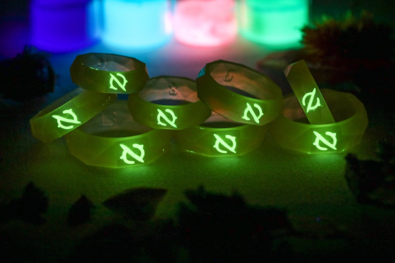 May include: A stack of eight glow-in-the-dark silicone rings with a green glow and a stylized letter "Z" on each ring.