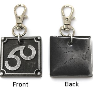 May include: A silver metal keychain with a black square charm. The front of the charm has a silver number 30 on it. The back of the charm is plain.