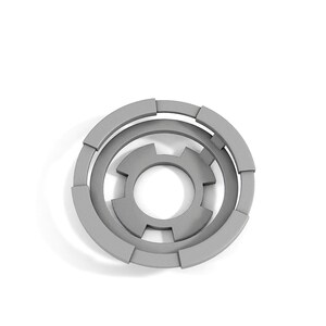 May include: A gray, circular, segmented design with concentric circles and a central hole. The design is made of multiple pieces that fit together.