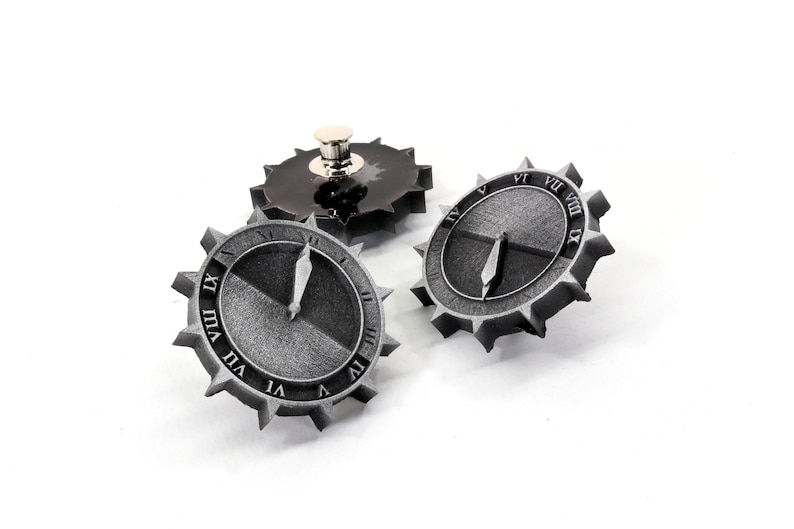 Puede incluir: Tres engranajes de color plateado con esferas de reloj en n&uacute;meros romanos. Los engranajes tienen un dise&ntilde;o en blanco y negro y se colocan sobre un fondo blanco.