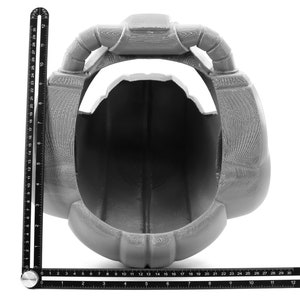 May include: A gray 3D printed helmet with a large opening in the front. The helmet has two large, rounded protrusions on the top.