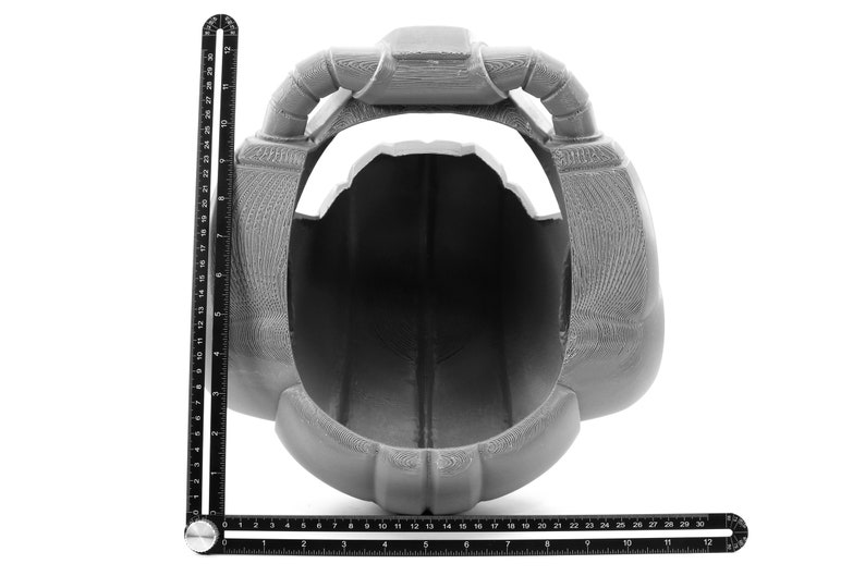 May include: A gray 3D printed helmet with a large opening in the front. The helmet has two large, rounded protrusions on the top.