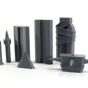 May include: A set of six grey 3D printed objects, including a spiked hammer, a pyramid, two tall rectangular blocks, and two smaller spiked objects.