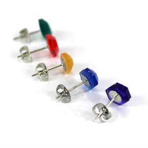May include: Five pairs of stud earrings with different colored gemstones. The earrings are silver and have a post back.