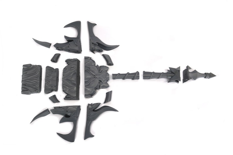 May include: A gray plastic model kit of a weapon with a long, spiked shaft and a decorative, ornate handle. The kit is disassembled into multiple pieces.