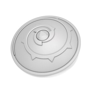 Puede incluir: Un escudo circular blanco con un dise&ntilde;o en espiral y un centro puntiagudo. El escudo tiene un borde elevado y una superficie texturizada.
