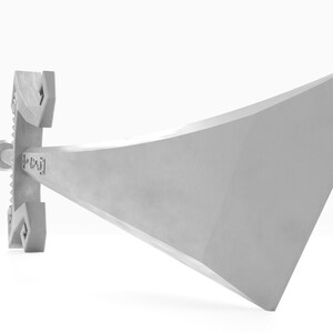 May include: A silver sword with a triangular blade and a detailed hilt. The sword is lying on a white surface.