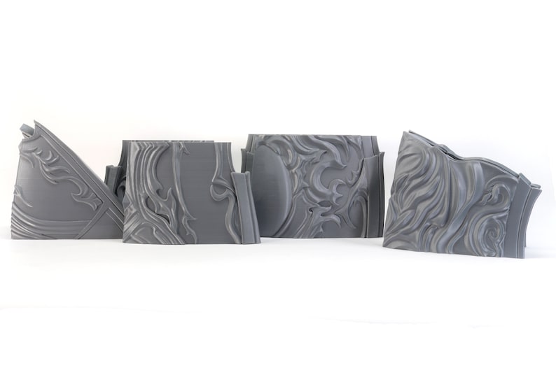 May include: Four gray 3D printed pieces of a decorative wall panel with a swirling, ornate design.