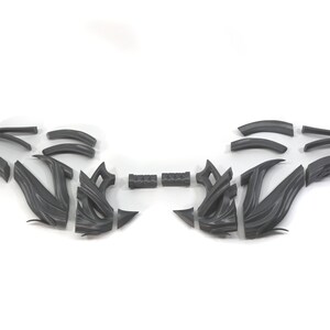 May include: A set of 16 gray plastic pieces that can be assembled into a decorative design. The pieces are shaped like curves and angles.
