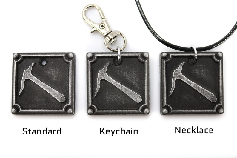May include: Three square, metal pendants with a pickaxe design. One is a standard pendant, one is a keychain, and one is a necklace. The pendants are dark gray with a silver pickaxe and are labeled "Standard", "Keychain", and "Necklace".