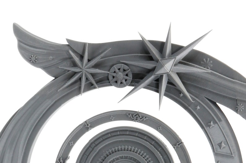 May include: A gray, stylized celestial archway with star and wing details. The design features multiple concentric arcs, with starburst and snowflake-like embellishments. The archway has a detailed, textured surface.