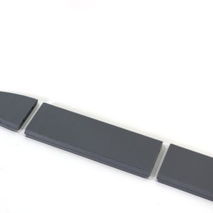 Puede incluir: Una espada gris se desmonta en cuatro piezas. La espada est&aacute; hecha de un material duro y duradero y tiene una punta afilada.