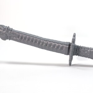 May include: A gray 3D printed sword with a dragon head handle and a detailed blade.