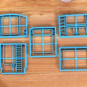 May include: Set of five blue plastic cookie cutters shaped like vintage video game cartridges.