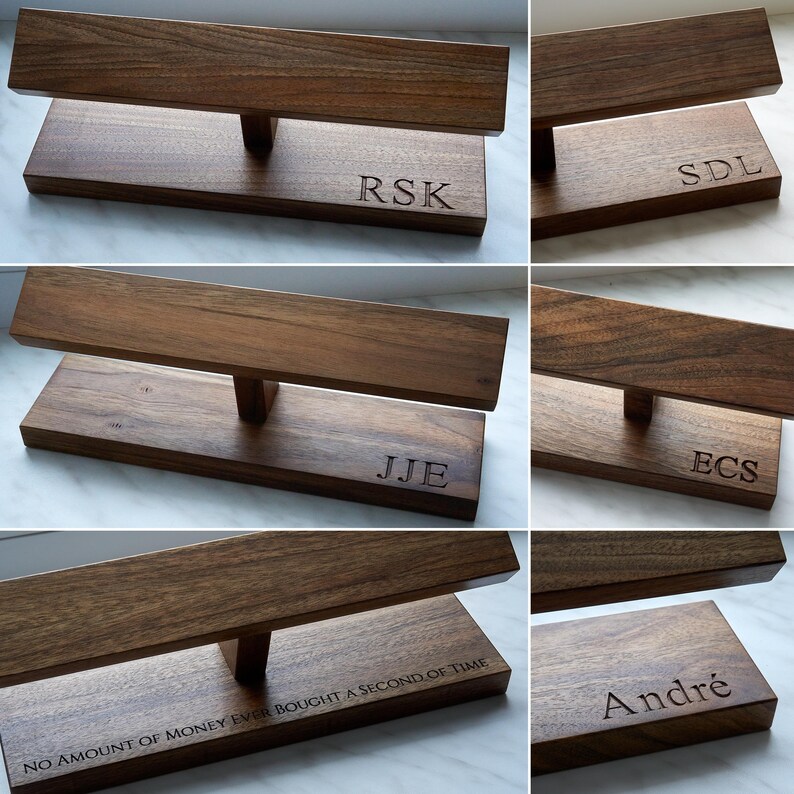 May include: Six wooden watch stands with different engraved names. The names are RSK, SDL, JJE, ECS, NO AMOUNT OF MONEY EVER BOUGHT A SECOND OF TIME, and Andr&eacute;.