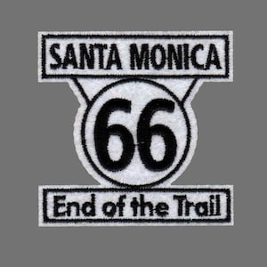 Peut inclure: Écusson brodé blanc et noir avec le texte "SANTA MONICA" au-dessus d'un cercle avec le numéro "66" et le texte "End of the Trail" en dessous. Fond gris.