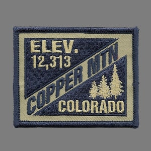 May include: A tan and navy blue embroidered patch with the text "ELEV. 12,313 COPPER MTN COLORADO" and a design of three pine trees.