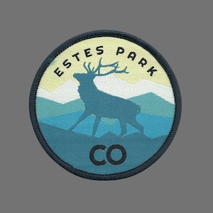 May include: A blue and yellow embroidered patch with a silhouette of an elk and the text "ESTES PARK CO".
