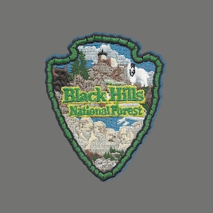 May include: Green and blue embroidered patch with a mountain scene and the text "Black Hills National Forest".