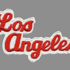 May include: Red embroidered patch with the words "Los Angeles" in a white outline.