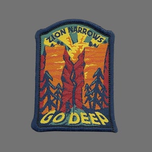 May include: A blue and yellow embroidered patch with the text "Zion Narrows Go Deep" and a depiction of a canyon with trees and a sunset.