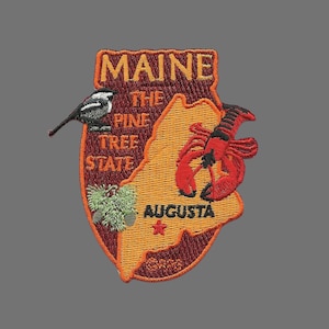 May include: Embroidered patch featuring the state of Maine, with the text "Maine, The Pine Tree State" and the city "Augusta". The patch also features a red lobster, a pine tree, and a black and white bird.