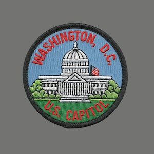 May include: Embroidered patch featuring the US Capitol building in Washington, D.C. The patch is blue, green, white, and red with the text "WASHINGTON, D.C. U.S. CAPITOL" around the building.