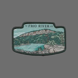 May include: Embroidered patch with a green, blue, and brown image of a river and mountains. The text "TX FRIO RIVER US" is stitched in black on the top of the patch.