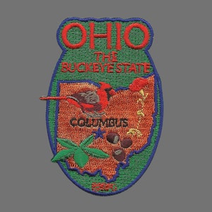 May include: A green and blue embroidered patch with the state of Ohio outlined in orange. The patch features a cardinal bird, the text "Ohio The Buckeye State", and the city of "Columbus".