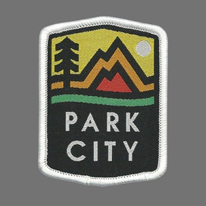 May include: White embroidered patch with a black background. The patch features a stylized mountain range with a yellow, orange, and red color scheme. A green tree is on the left side of the mountains. The text "PARK CITY" is in white letters below the mountain range.