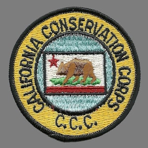 May include: A yellow circular patch with black trim, featuring the text "California Conservation Corps" and "C.C.C." in black. The center of the patch displays the California state flag with a red star, a brown bear, and green foliage.