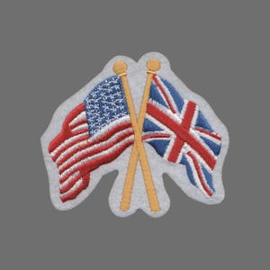 May include: Embroidered patch featuring the flags of the United States and the United Kingdom crossed against each other. The American flag has red and white stripes with blue stars. The British flag has a blue background with a red cross.