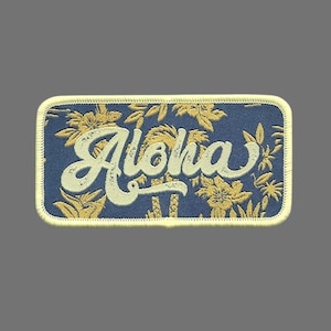 May include: A blue embroidered patch with a yellow floral pattern and the word "Aloha" in white lettering.