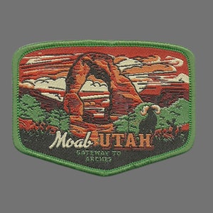 May include: Green embroidered patch with a red, orange, and brown image of Delicate Arch in Arches National Park, Utah. The text "Moab Utah Gateway to Arches" is embroidered in white on the patch.