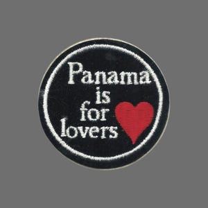 May include: Embroidered patch with the text "Panama is for lovers" in white on a black background. A red heart is on the right side of the patch. The patch is circular with a white border.