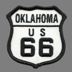 May include: A white and black Route 66 patch with the text "OKLAHOMA US 66" in black.
