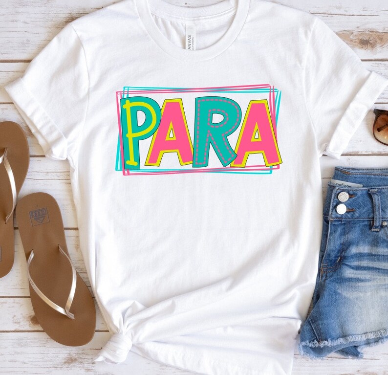 May include: White t-shirt with the word "PARA" in colorful, outlined letters. The letters are pink, yellow, and teal with a stitched effect.