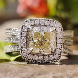 Light yellow crushed ice cushion engagement ring displayed on a velvet stand.