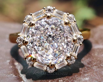 May include: A gold ring with a large, round, clear diamond center stone surrounded by smaller diamonds in a geometric pattern.