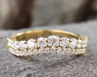 May include: A gold band with two rows of round, clear diamonds. The band is curved and has a delicate design.
