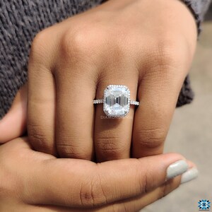 Emerald cut moissanite engagement ring presented in an open ring box, ready for a proposal, with the 14k white gold band gleaming