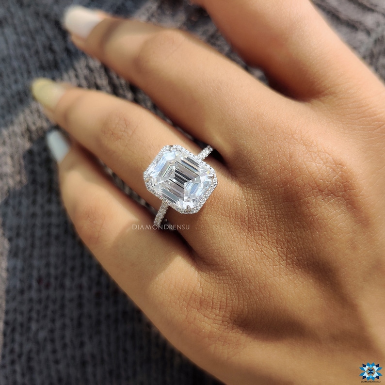 Angled perspective of a halo engagement ring, showcasing the emerald cut moissanite's depth and the halo's circular arrangement