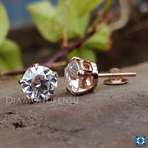 Pode incluir: Um par de brincos de press&atilde;o de ouro rosa com pedras de moissanita redondas e transparentes engastadas em garras.