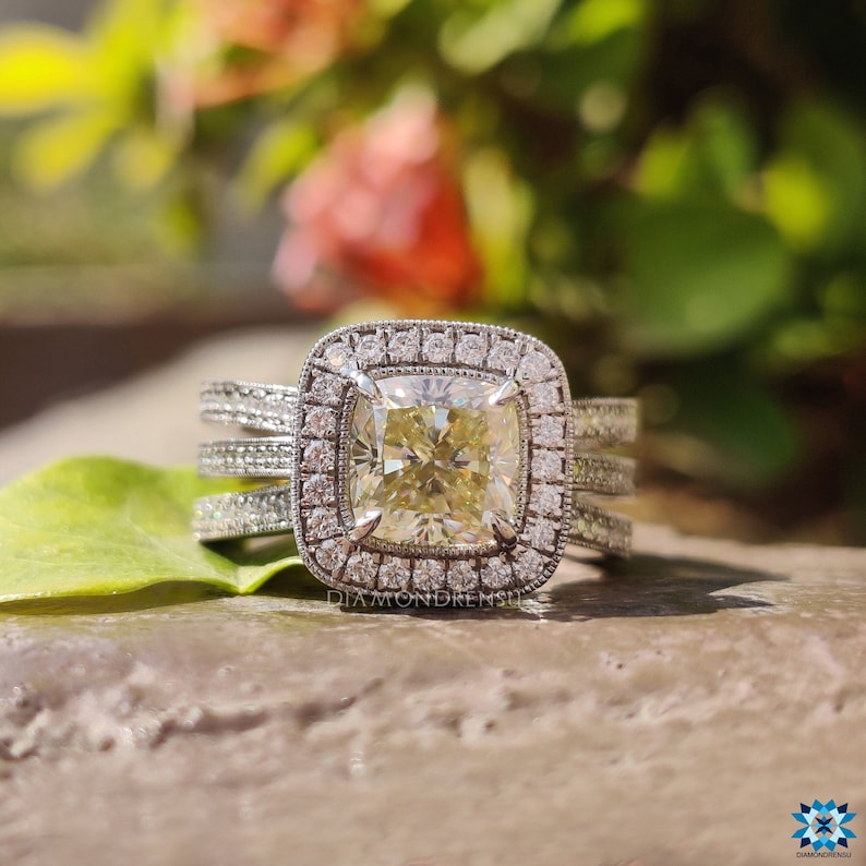Light yellow crushed ice cushion engagement ring displayed on a velvet stand.
