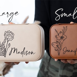 K&ouml;nnte beinhalten: Zwei rechteckige Schmuckk&auml;stchen, eines beige und eines braun, werden gezeigt. Das beige Etui ist mit "Large" beschriftet und hat ein Blumendesign und den Namen "Madison". Das braune Etui, beschriftet mit "Small", hat ein Blumendesign und den Namen "Jennifer".