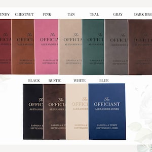 May include: A collection of personalized officiant books in various colors, including burgundy, chestnut, pink, tan, teal, gray, dark brown, black, rustic, white, and blue. Each book features the text "The Officiant" and personalized names and dates.